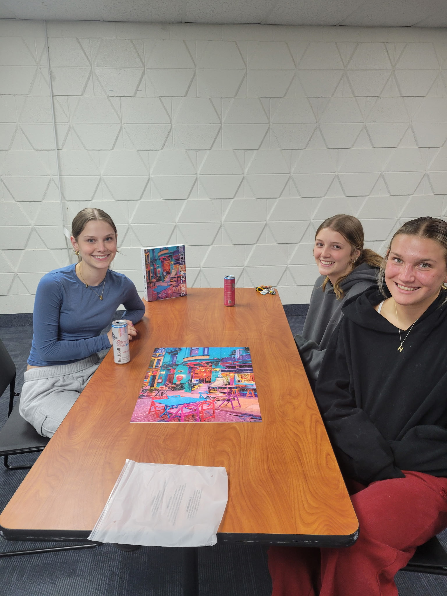 The second-place three-member team of the Adult Jigsaw Puzzle Competition, posing around their finished 500-piece puzzle.